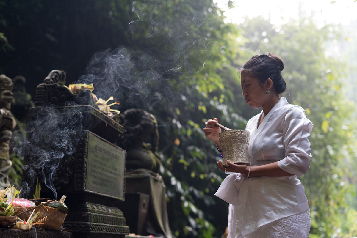 Tya priestess in Bali performing water blessing in Sebatu water temple
